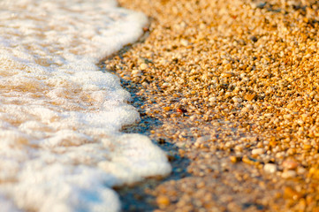 sea wave over the pebbles on the beach, abstract natural background