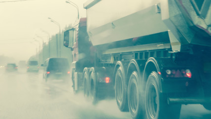 Obraz na płótnie Canvas Traffic in heavy rainfall, no visibility. Blurred silhouettes of vehicles