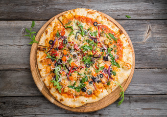 Delicious Italian pizza with vegetables on a wooden table