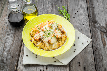 Pasta bake with broccoli and chicken. On a wooden table