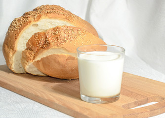 Homemade bread, sliced on a wooden board with milk