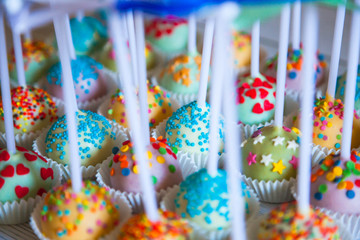 Fototapeta na wymiar Colorful baked cakepops on white wooden background