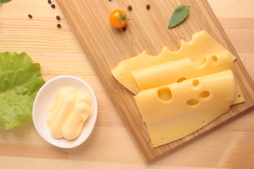 Maasdam cheese sauce on a board and a grater