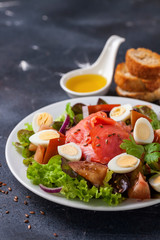 Healthy food - vegetables and salmon salad on a dark background. Selective focus. Copy space
