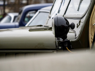 The headlight on the wing of an old off-road car of green color