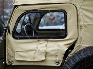 Window from the tarpaulin of the old 4x4 car of green color