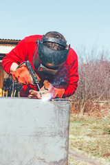 Welder puts a seam on metal electro arc welding, photo toning