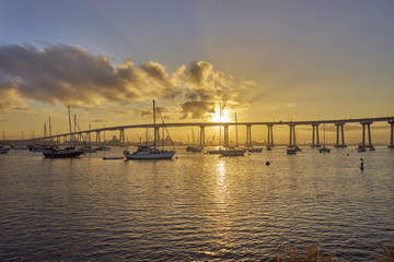 boats under and beautiful sunrise over the Coronado Bridge, San Diego California