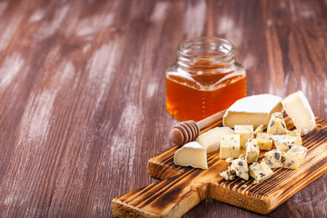 Pieces of various cheese on a board. Cheese plate. Selective focus. Copy space