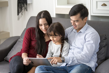 Kid using tablet with family and smiling together, happy family concept, 3 person.