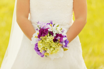 Obraz na płótnie Canvas Bride holding a colorful bouquet 