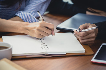 Closeup woman hand holding pen for writing on the book, woman working concept,