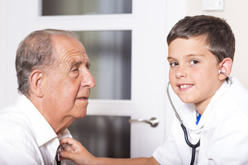 Kid examines his grandfather using stethoscope