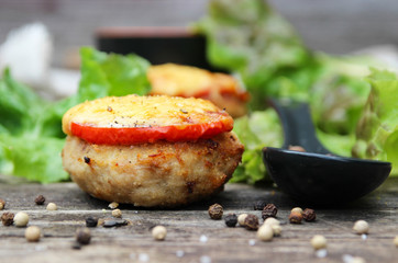 Grilled meatballs with tomato and cheese.