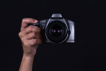 Hand holding Camera on black background