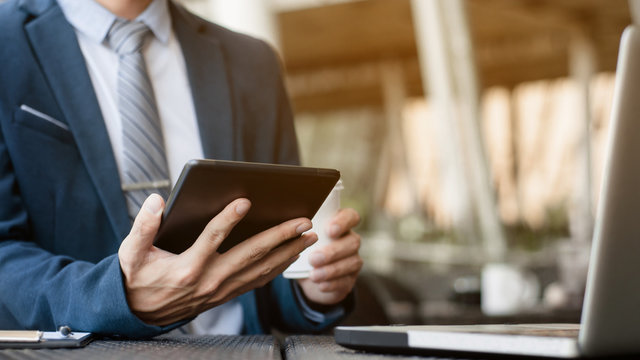 Businessman Working With Digital Tablet And Laptop With Financial Business Strategy At A Coffee Shop Cafe