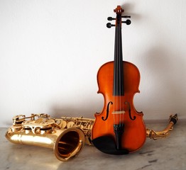 Fototapeta na wymiar Violin and saxophone on a marble surface