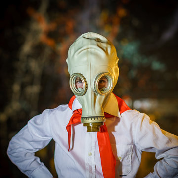 Young soviet pioneer dressed in red tie and gas mask