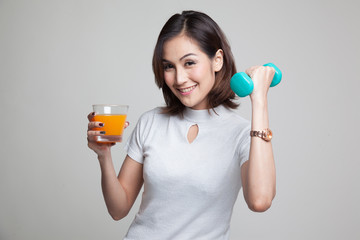 Young Asian woman with dumbbell drink orange juice.