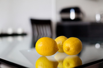 Still life - three lemons on the glass table