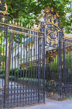     Paris, parc Monceau, wrought iron gate and luxury facades
