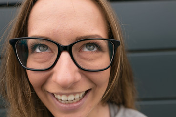 Large portrait of a girl with glasses on a gray background