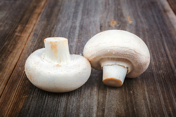Button mushrooms on the a wooden background.