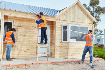 Handwerker Team arbeitet an Holzhaus
