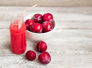 Vitamin, fruit drink, milkshake. Plums on a wooden background.