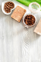 Homemade skin care. Coffee soap, coffee scrub, coffee grains on wooden background top view copyspace