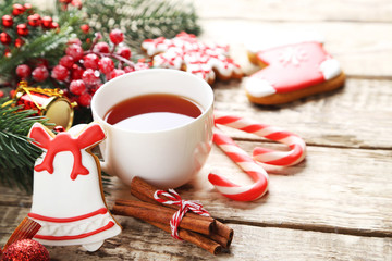 Christmas cookies with cup of tea on a brown wooden table