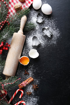 Christmas tree branch with cinnamon, eggs, flour and anise star on wooden table