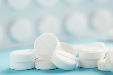 Heap of white pills on blue background