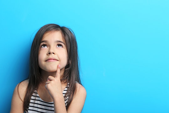 Beautiful little girl in dress on blue background