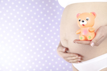 Teddy bear and Happy pregnant woman