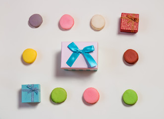 Colorful macaroons and gift boxes pattern on beige background