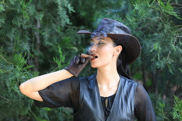 Portrait of a cowboy girl with a cigar