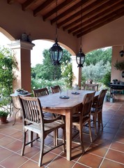 Cosy, french patio in provence with wooden garden furniture, surrounded by beautiful, white roses