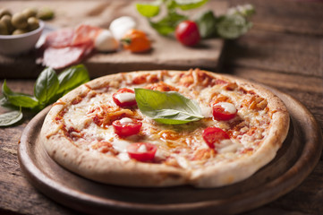 rustic italian pizza with mozzarella, cheese and basil leaves