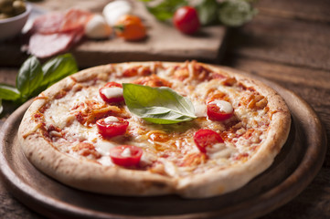 rustic italian pizza with mozzarella, cheese and basil leaves