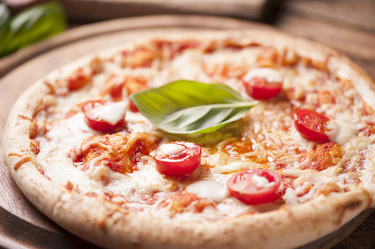 rustic italian pizza with mozzarella, cheese and basil leaves