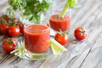 Tomato juice in a glass with celery and tomatoes