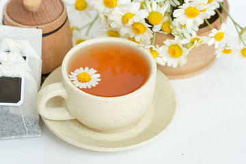 cup of herbal chamomile tea with fresh daisy flowers. doctor treatment and prevention of immune concept, medicine - folk, alternative, complementary, traditional medicine 