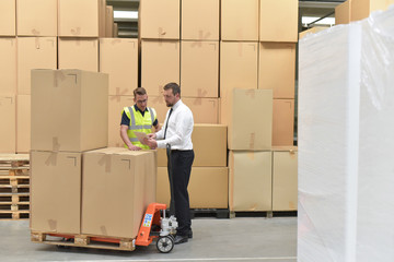 Zusammenarbeit  von Manager und Arbeiter im Warenlager // Cooperation between manager and worker in...