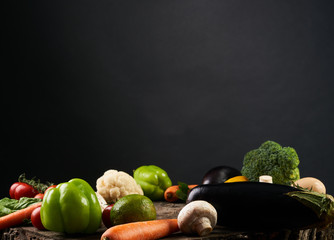 Variety of  vegetables, on the wooden table isolated on black background, top view, copy space, selective focus.
