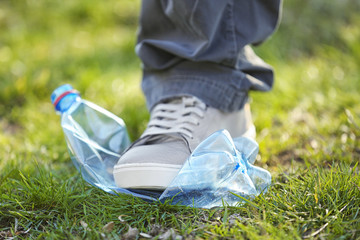 Volunteer picking up litter from grass, closeup