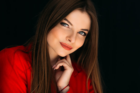 Expressful portrait of young woman in red clothes looking into the camera