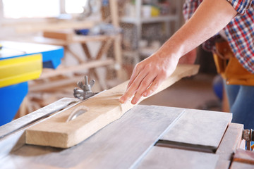 Fototapeta na wymiar Carpenter sawing timber in workshop