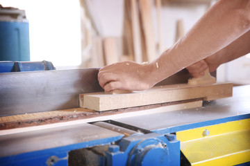 Carpenter working with timber in shop