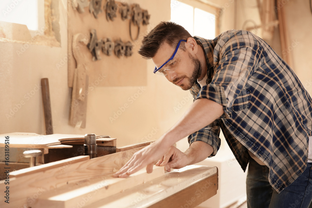 Wall mural carpenter working with timber strip in shop